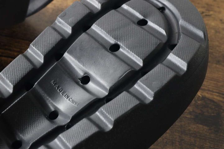 黒いEVAサンダルの裏側。滑り止めのような凹凸のあるソールが写っている