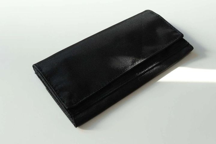 黒いポリエステル製のカジュアル長財布が閉じた状態で置かれている