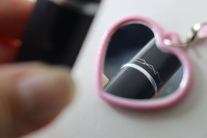 ハート型マイメロディミラーに映るMACの口紅本体のクローズアップ