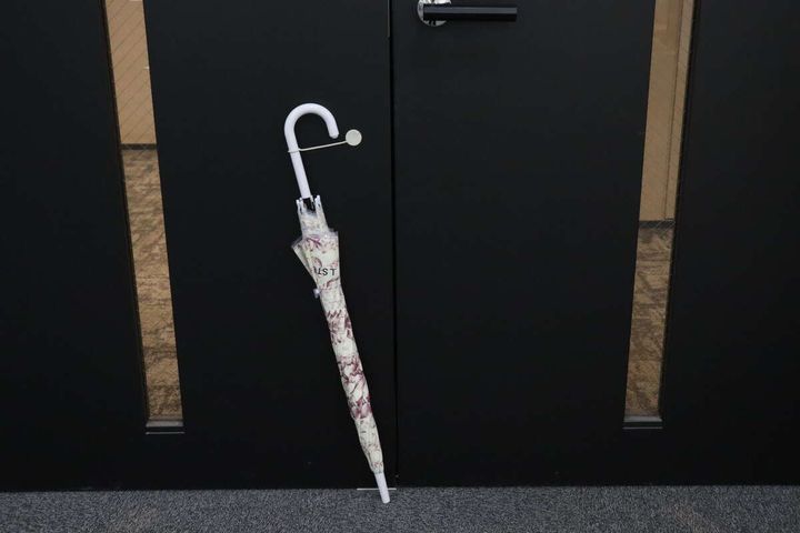 柄物の傘が玄関の黒い金属製ドアにマグネットで固定されている