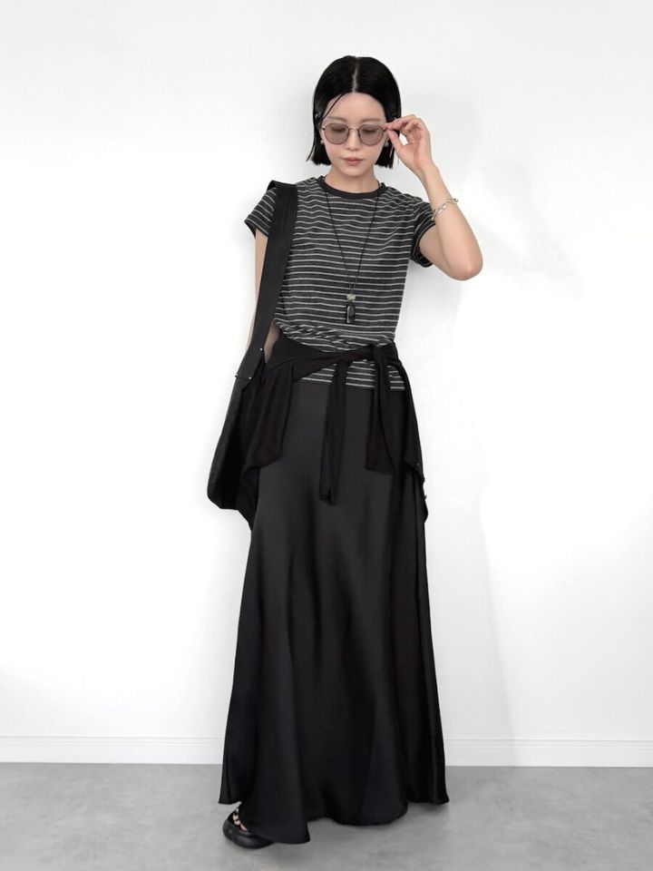 ボーダーTと黒スカート、腰巻きカーディガン、サングラスの女性