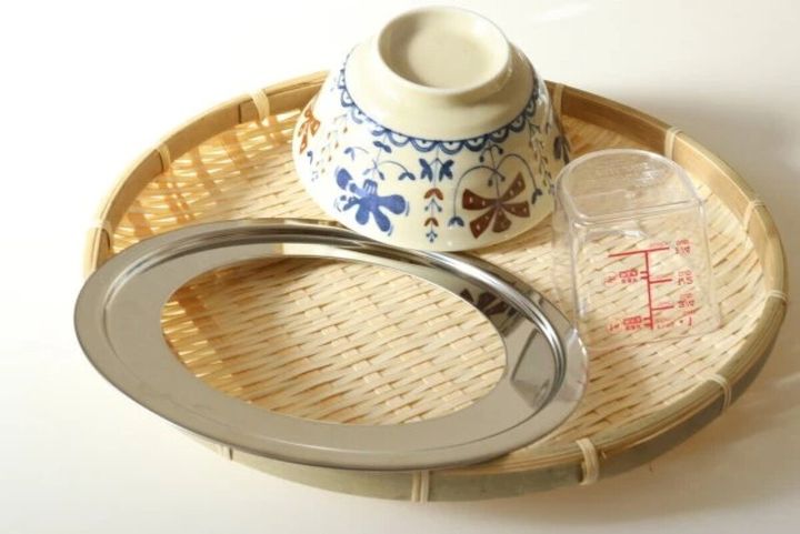 竹ざるの上で食器と計量カップを乾燥させている様子