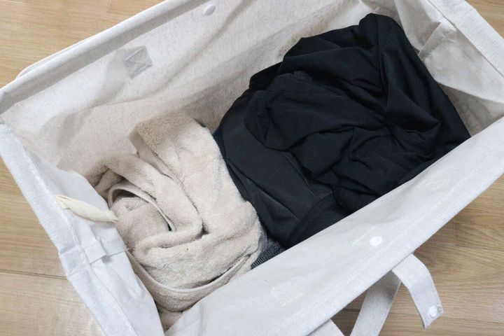 ランドリーバッグに黒い衣類とバスタオルを入れた様子