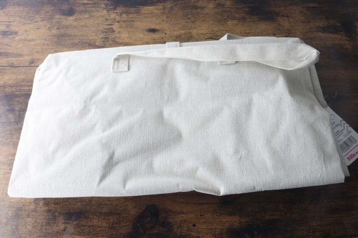 たたんでコンパクトになった白いランドリーバッグ