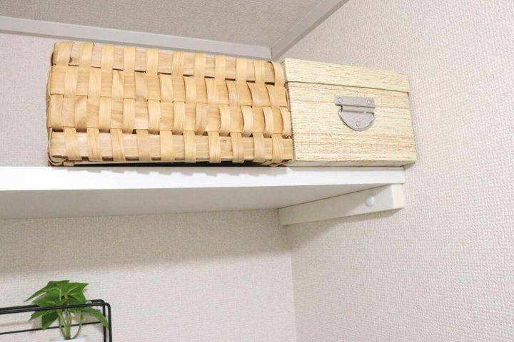 棚の上に置かれた、木目調収納ボックスと別のラタン風カゴ