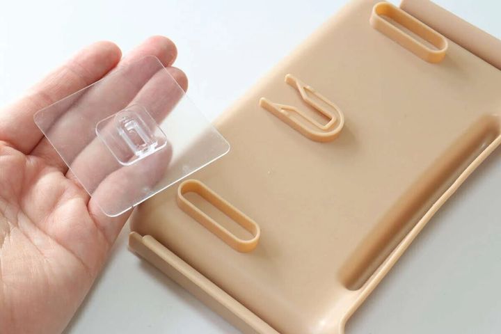 スポンジホルダー（水切りネット用）の設置用ツメ付きシートを手に持つ