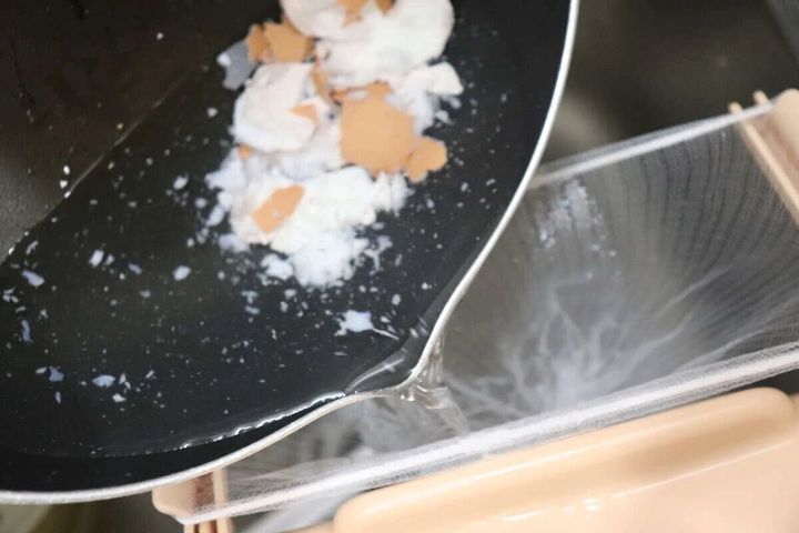 水切りネットをセットしたホルダーに鍋から水と生ゴミを流す様子