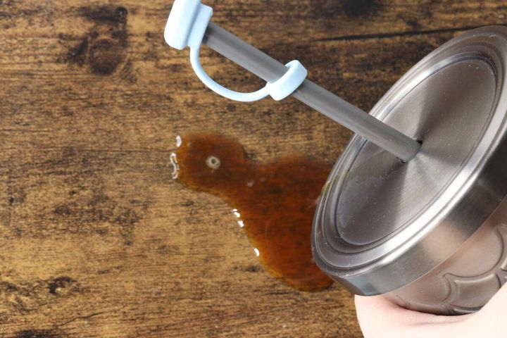 ストローキャップを装着したタンブラーを傾け、液体がこぼれている様子