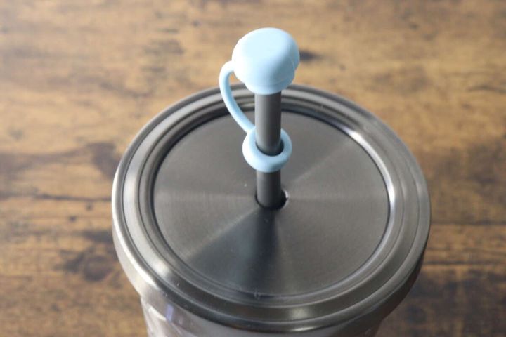 タンブラーのストローに装着された水色のストロートッパーキャップが閉まっている