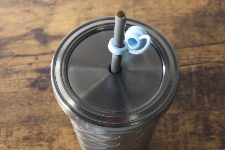 タンブラーのストローに水色のストロートッパーキャップを装着している