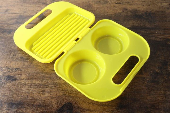 黄色いレンジ用目玉焼き調理器の蓋を開けた状態。卵を2個入れるくぼみが見える。