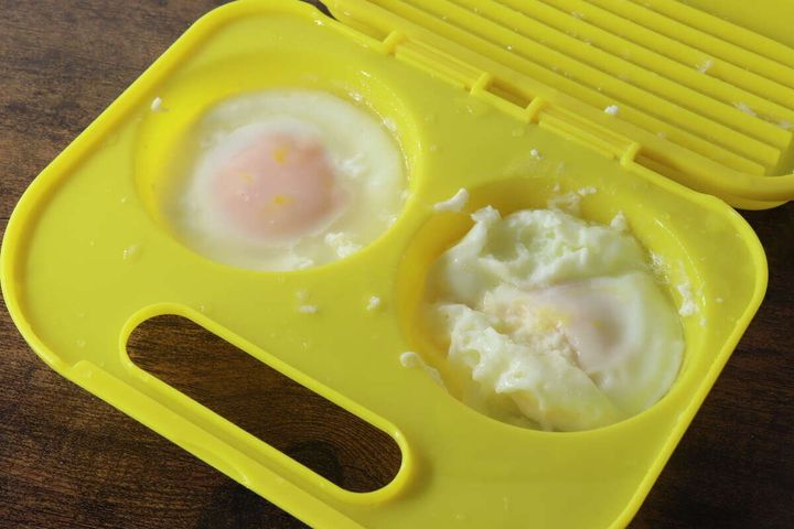 黄色い調理器で調理された目玉焼き2個。片方は破裂し、もう片方は半熟状態。