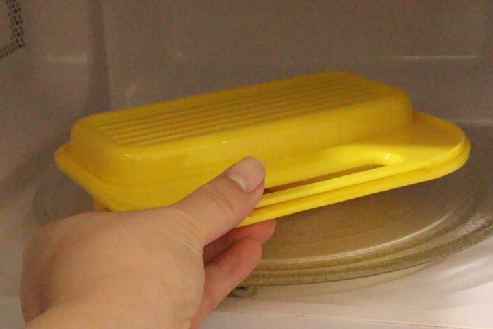 黄色いレンジ用目玉焼き調理器を電子レンジに入れている手元。