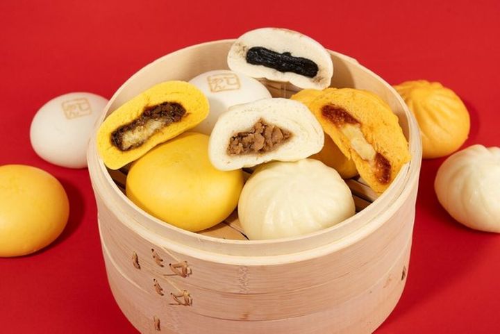 赤い背景の蒸籠にカットされた中華まんが複数並ぶ