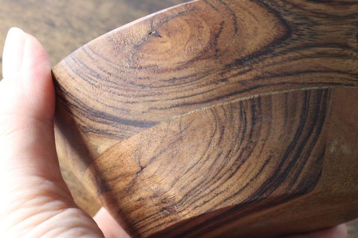 アカシアボウルの側面を指で触り木目と継ぎ目を見せる