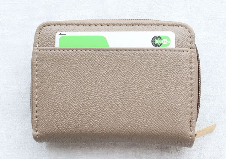 茶色のミニ財布の背面ポケットにSuicaカードが入っている。