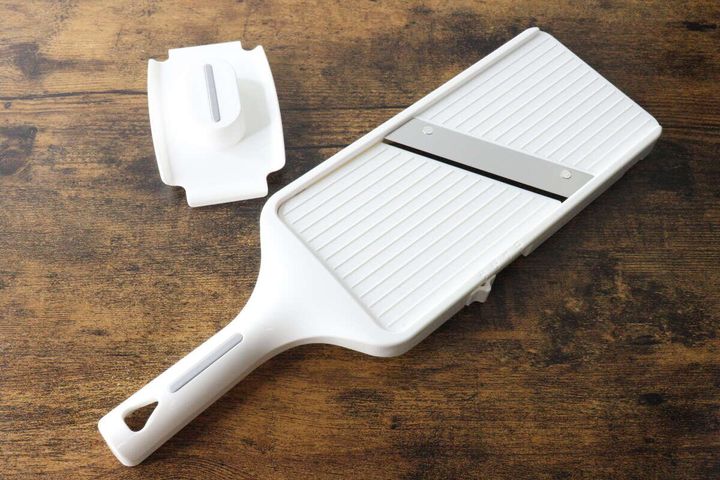 木目のテーブルに置かれた白い厚み調整スライサーとホルダー