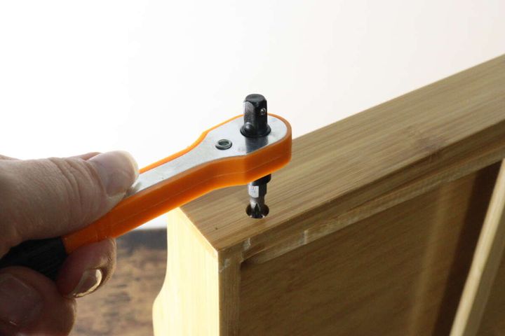 ラチェットツールセットを使って木製の箱のネジを締めている作業風景