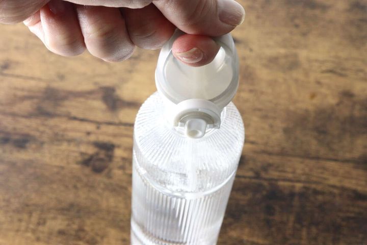 指をキャップの穴に引っ掛けペットボトルを持ち運ぶ様子