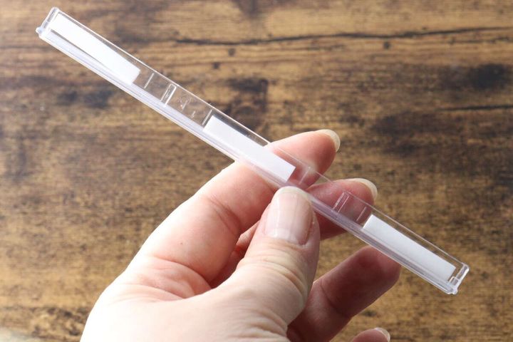 女性の指で持ったハンガーストッパーの裏面