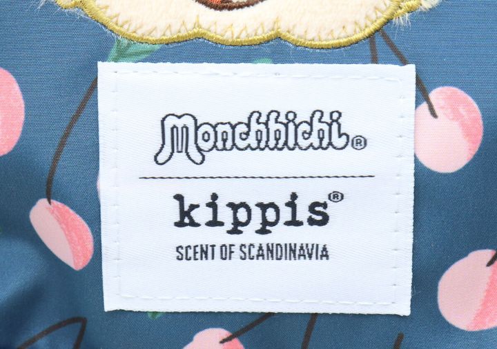紺色ポーチのモンチッチとkippisのロゴタグのアップ