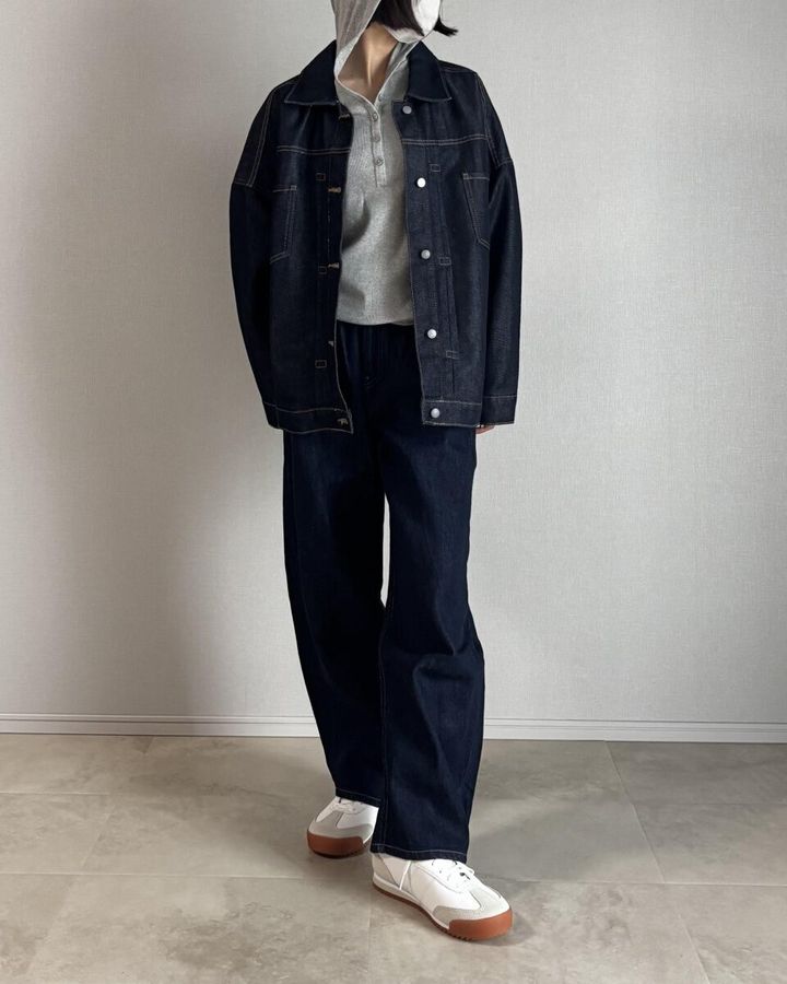 グレーのフーデッドリブTにデニムジャケットとデニムパンツの女性