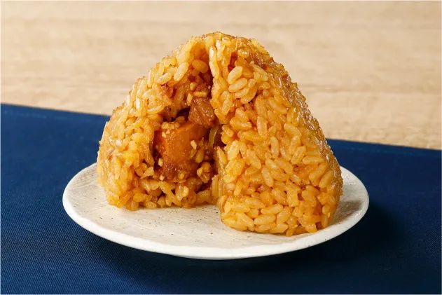 醤油色の炊き込みごはんに具材がのぞく三角おにぎりの断面