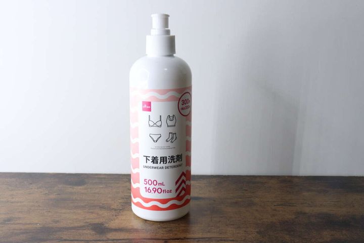 白いポンプ式ボトルに入ったダイソーの下着用洗剤が木製のテーブルに置かれている