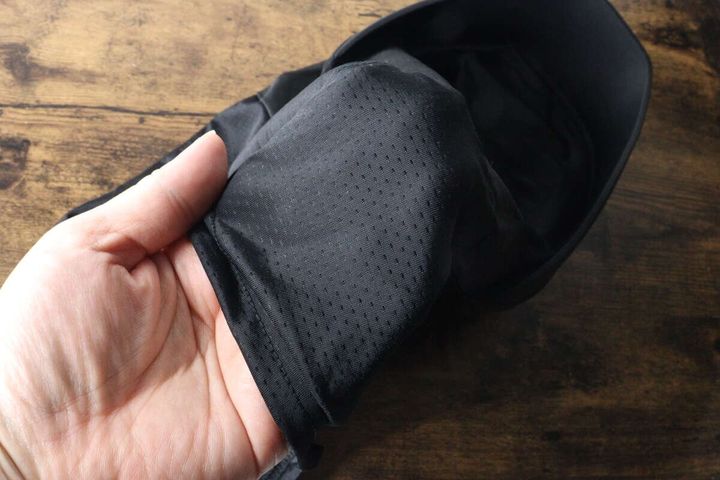 手がフェイスガードのメッシュ部分を触っている様子。生地の質感と通気性の良さが伝わる