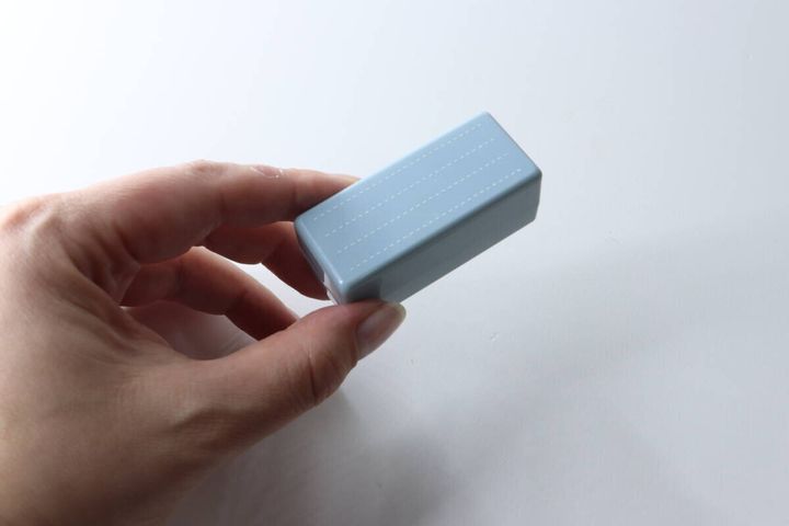 女性がセリアの罫線練習スタンプ本体を手に持っている