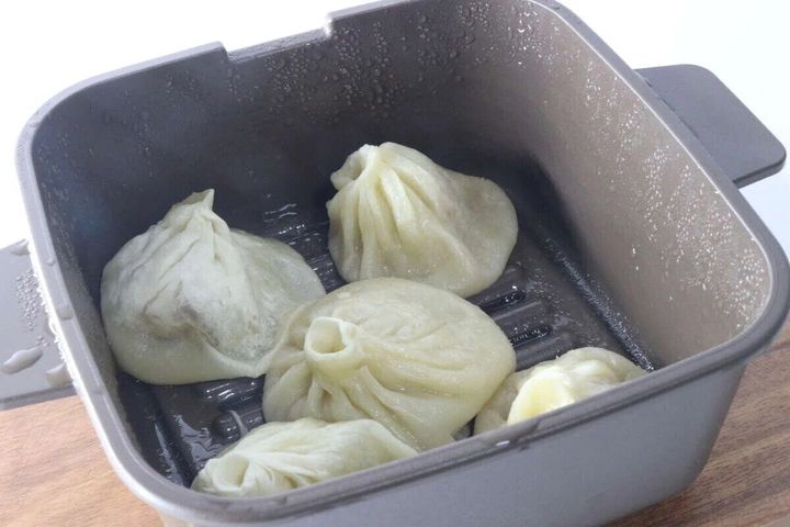 マルチクッカーのプレートに蒸し上がった餃子が4つ並んでいる