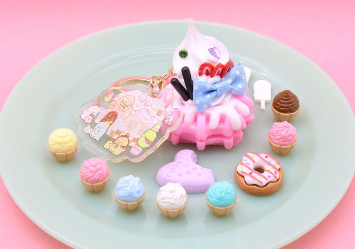 ピンクのワッフルチャームと、様々な種類のミニチュアスイーツが緑色の皿に並べられている