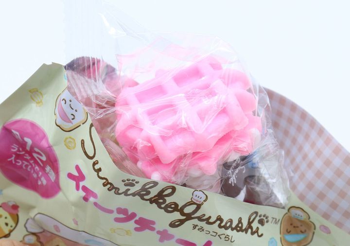 パッケージの袋からピンクのワッフルチャームが少し見えている様子