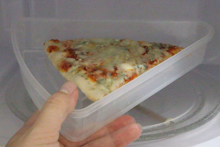 ピザ入り保存容器を電子レンジに入れている様子