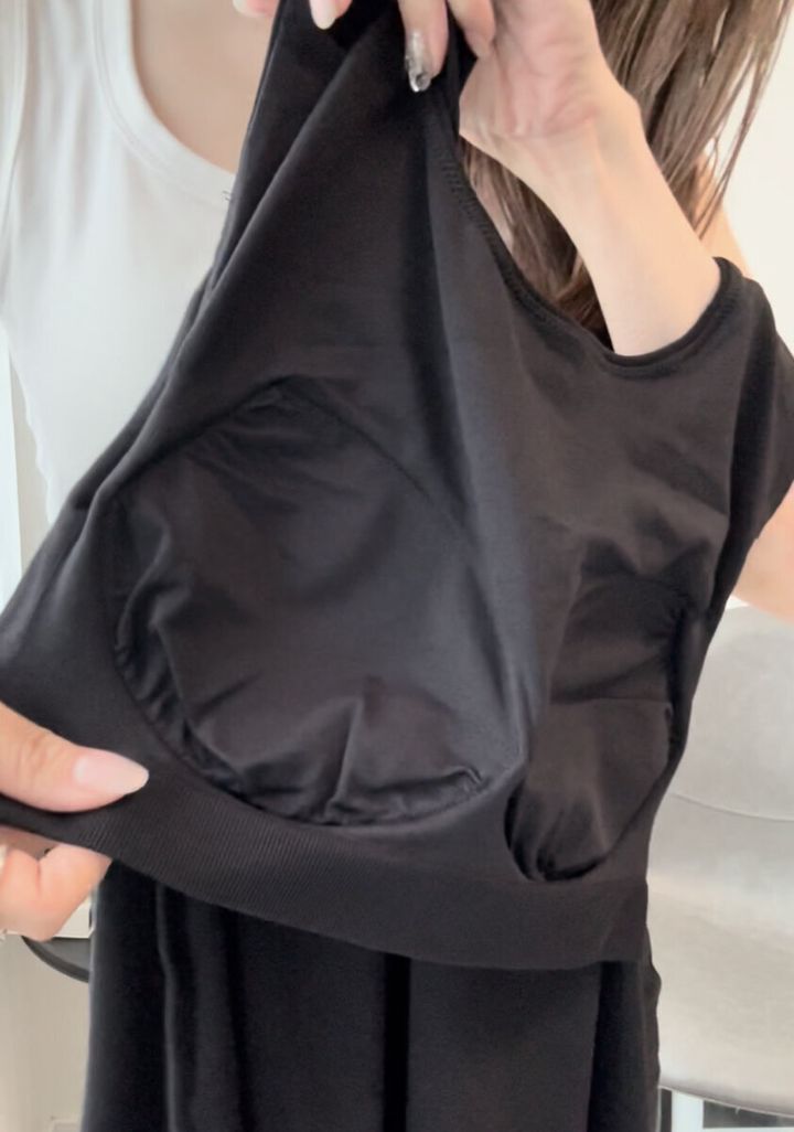 女性がカップ付きトップスの内側を見せている