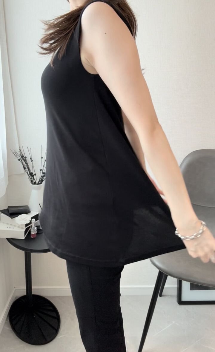 黒いトップスを着た女性が横向きで裾を広げている