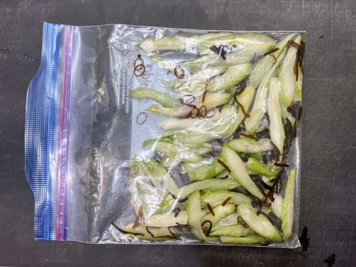 保存袋に入ったセロリに、塩昆布と赤唐辛子の小口切りが加えられている