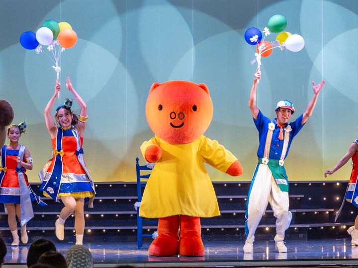 カラフルな風船の束と一緒に踊るグランティ