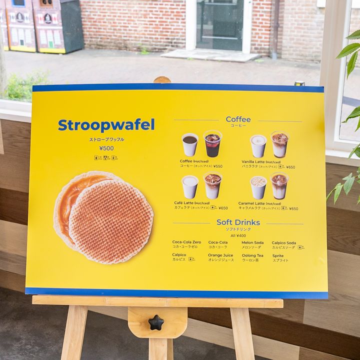 ストロープワッフルとコーヒー、ラテ、ソフトドリンクが並ぶ店内メニューボード