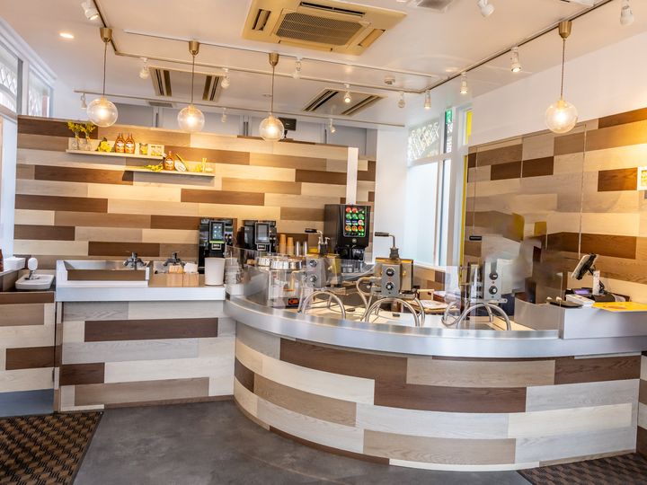 木目の壁と曲線カウンターにワッフル焼き機が並ぶ「STROOPWAFEL」の店内
