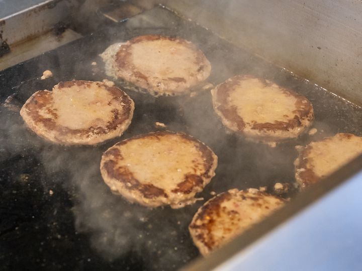 鉄板の上でビーフパティを焼き上げるオープンキッチン