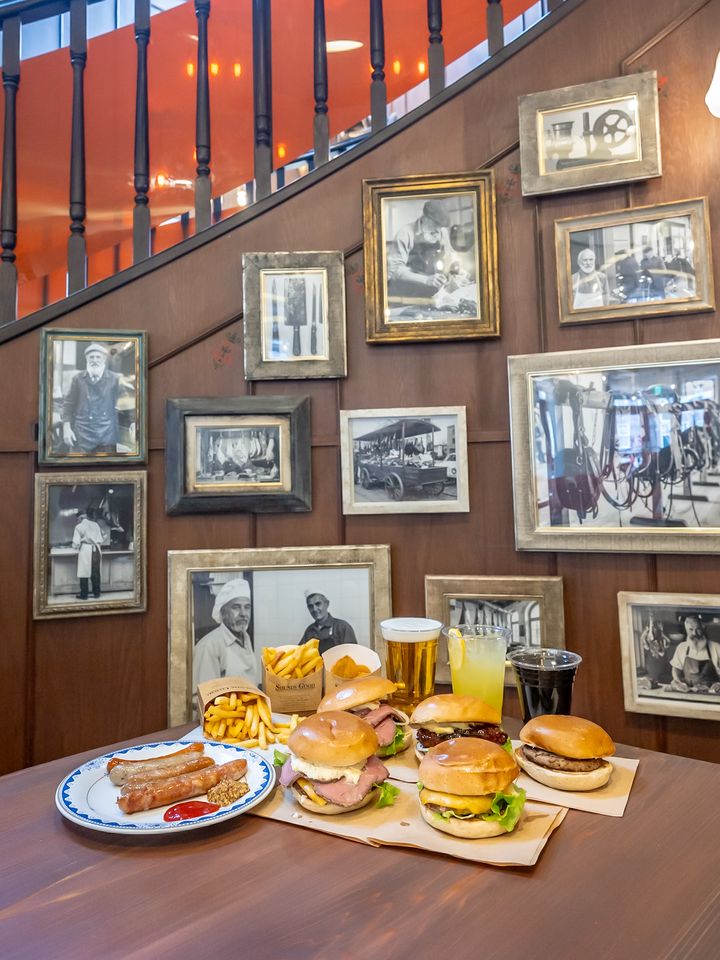 階段沿いに額装写真が並ぶデ フォンテイン グリルバーガーの店内と料理