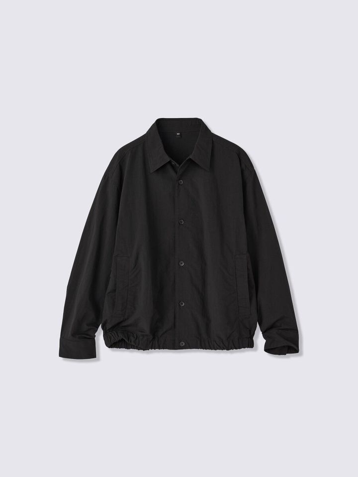 黒色のドライユーティリティシャツを平置きで撮影。胸元にポケット。