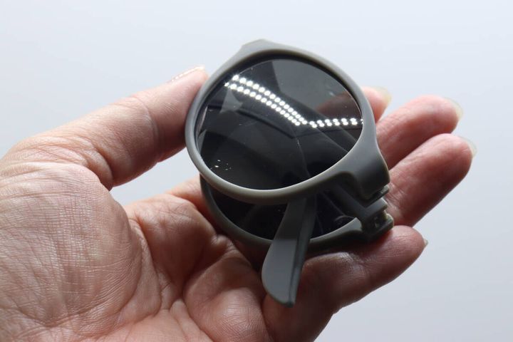 手のひらに乗せた「折りたたみサングラス」を折りたたんだ状態