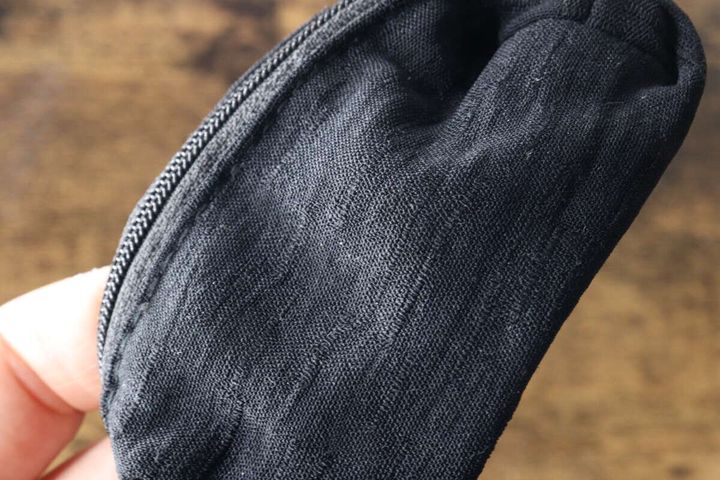 黒いキーホルダーポーチの生地をアップで撮影。ニュアンスのある凹凸感がわかる