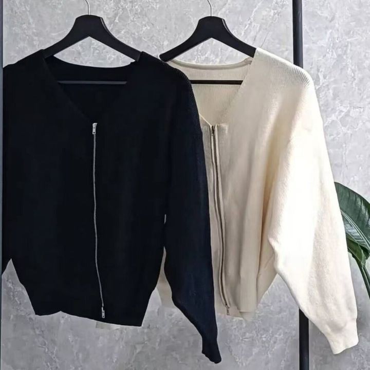 黒とオフホワイトのダブルジップカーディガンがハンガーに吊るされている