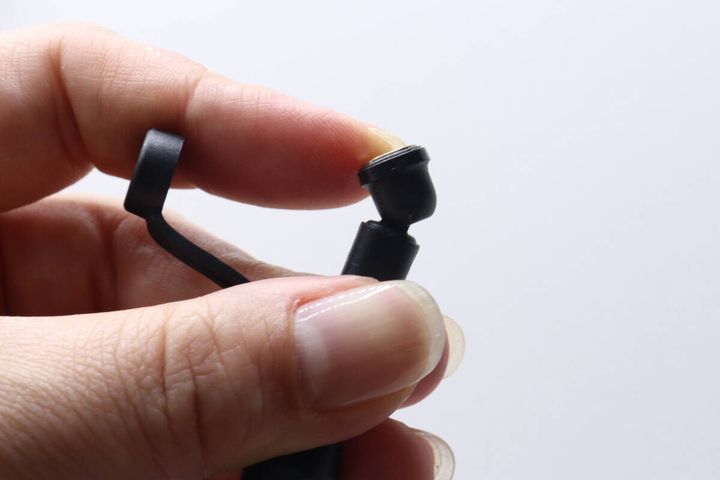 女性の指がマグネット端子ケーブルの先端キャップを外している