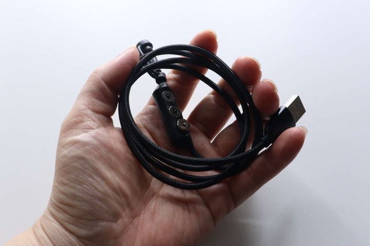 女性の手のひらに丸めて乗せられたマグネット端子ケーブル