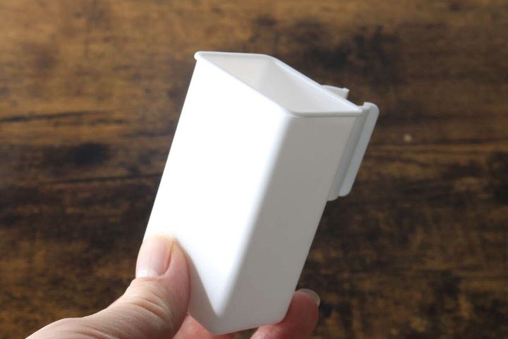 白いフローリングワイパー用収納ポケットを指で持つ