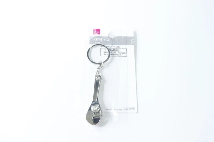 ダイソーのタグが付いたモンキーレンチ型キーホルダーが袋に入っている